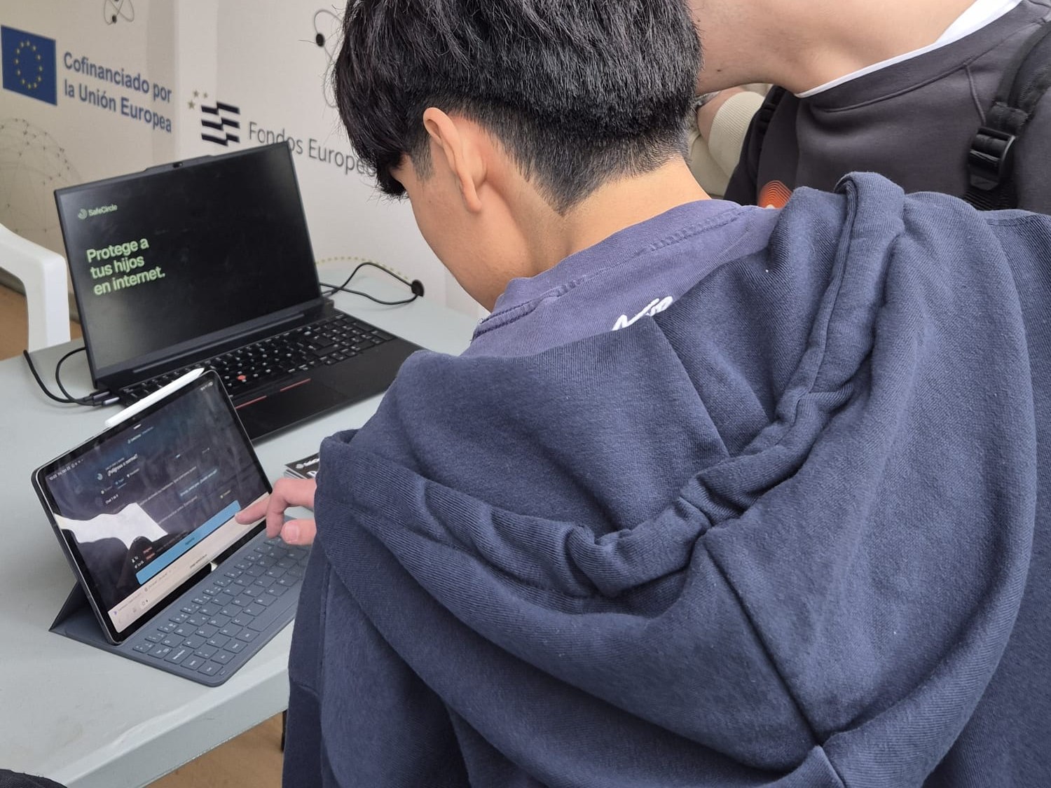 Un visitante prueba la demo de SafeCircle en la tablet del stand