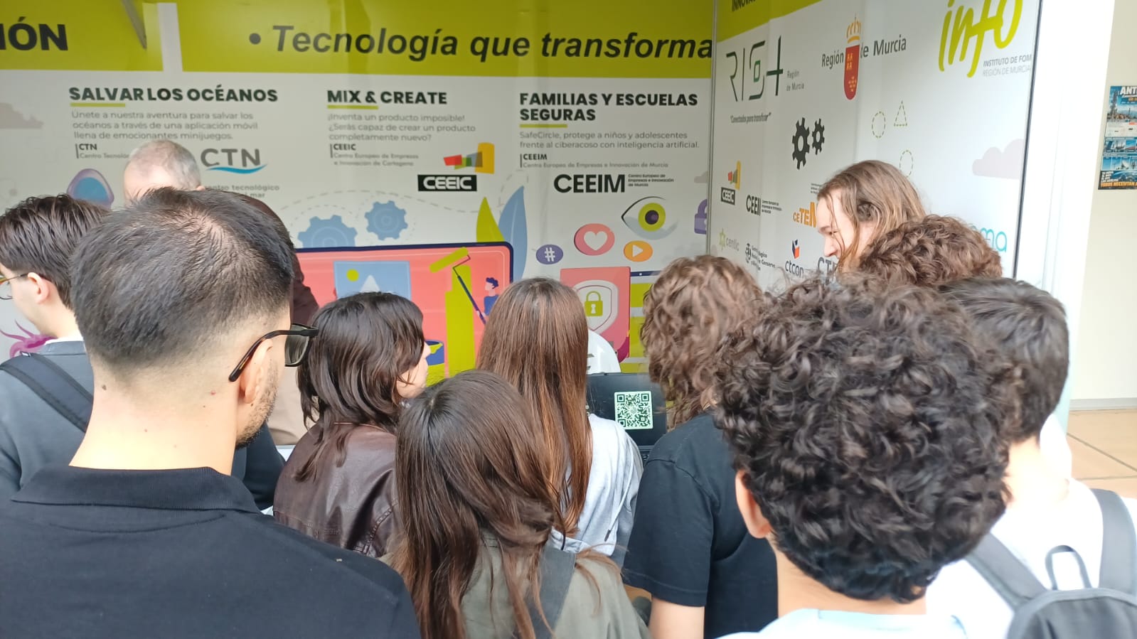 Visitantes alrededor del stand de SafeCircle en SECyT 2026, con el código QR en la pantalla